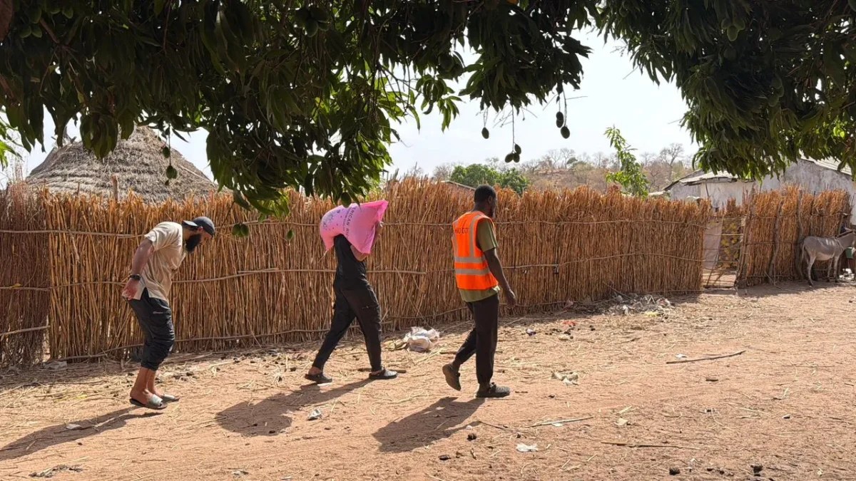 HMD field team carrying food packages to households