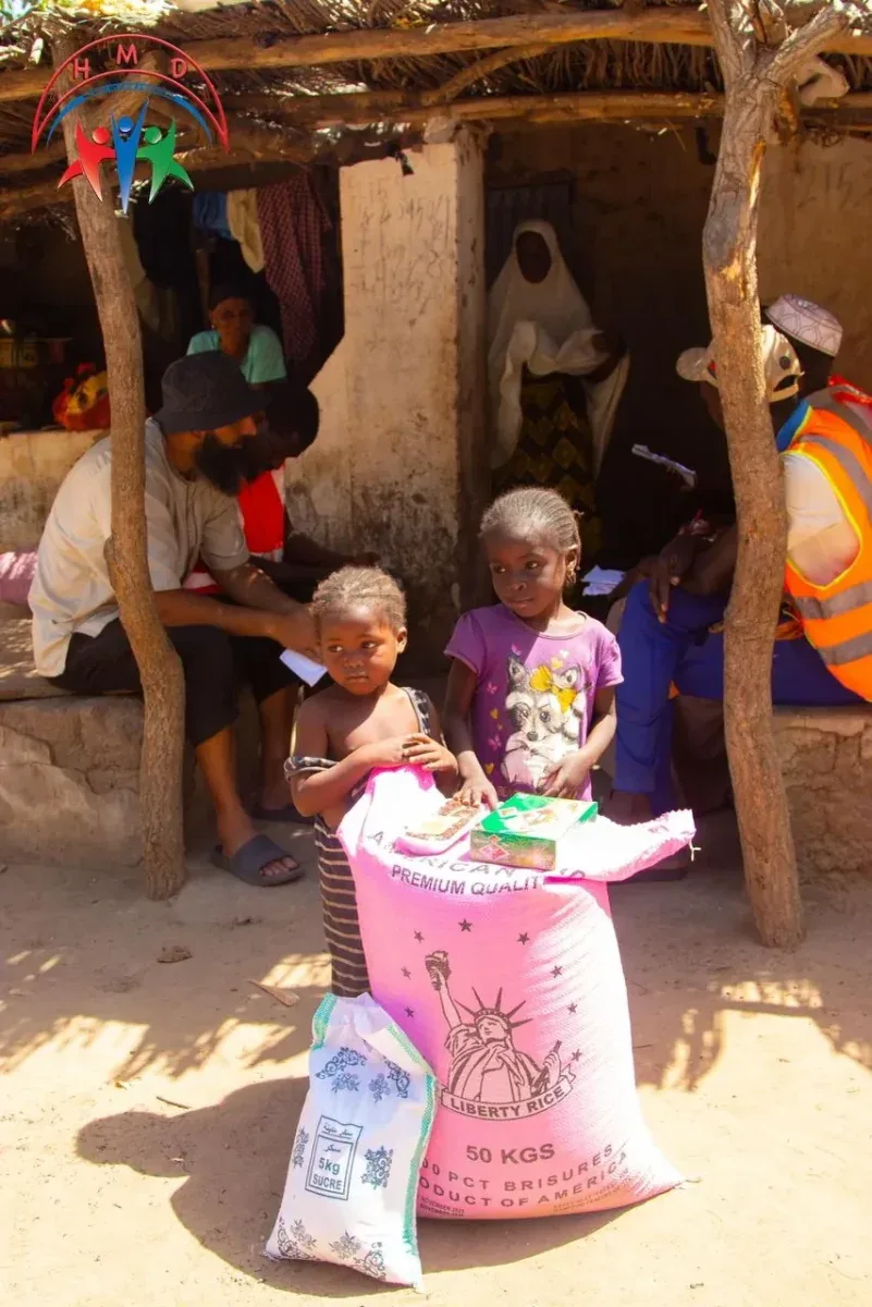 Two children with the food pack HMD delivered to their family